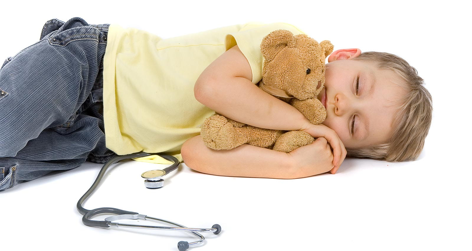 A young patient holds his teddy bear