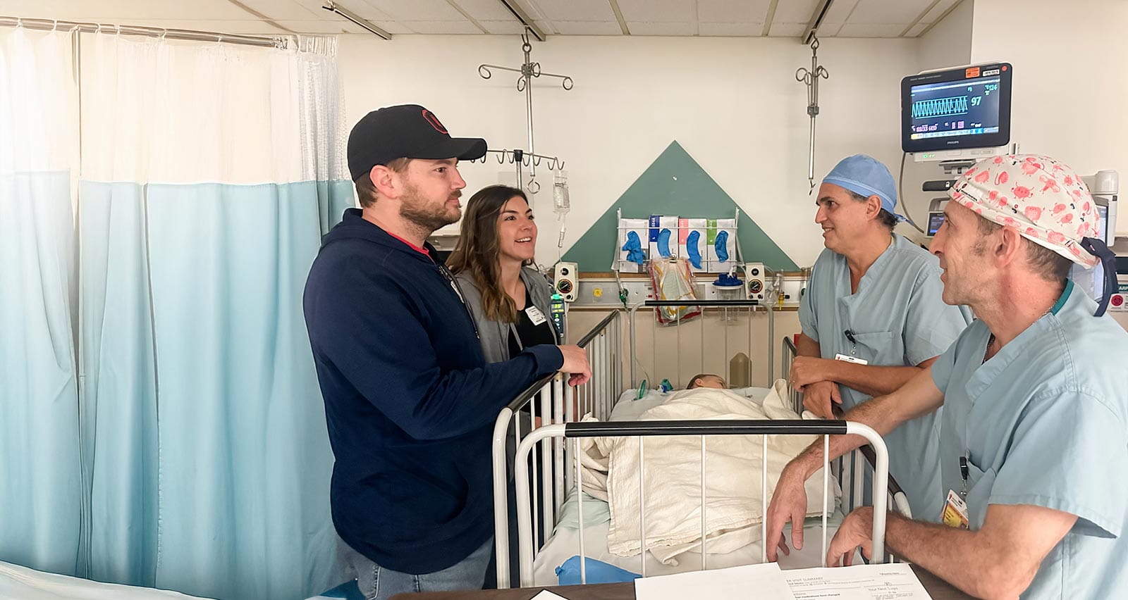 Dr. Pedro Jose Lopez talking with parents after surgery in recovery room