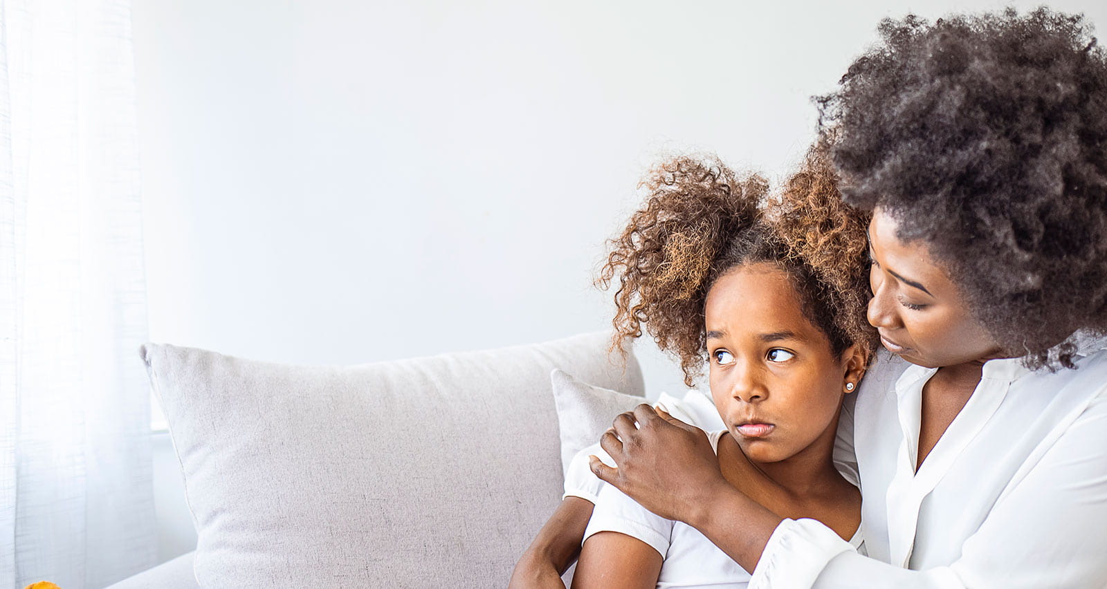 A mother consoles her worried young daughter