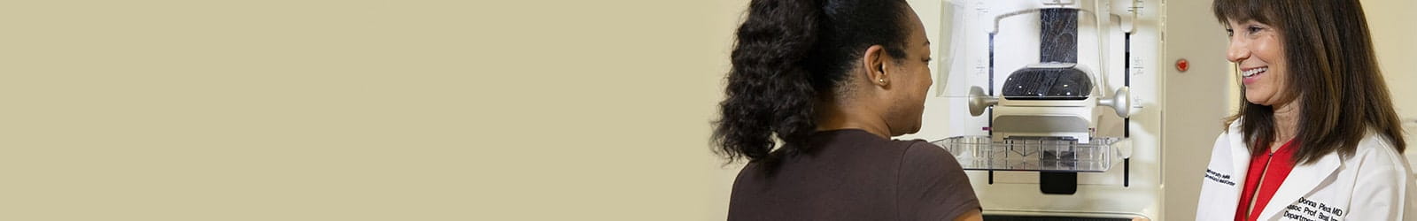 Donna Plecha, MD speaking with woman at mammography machine.