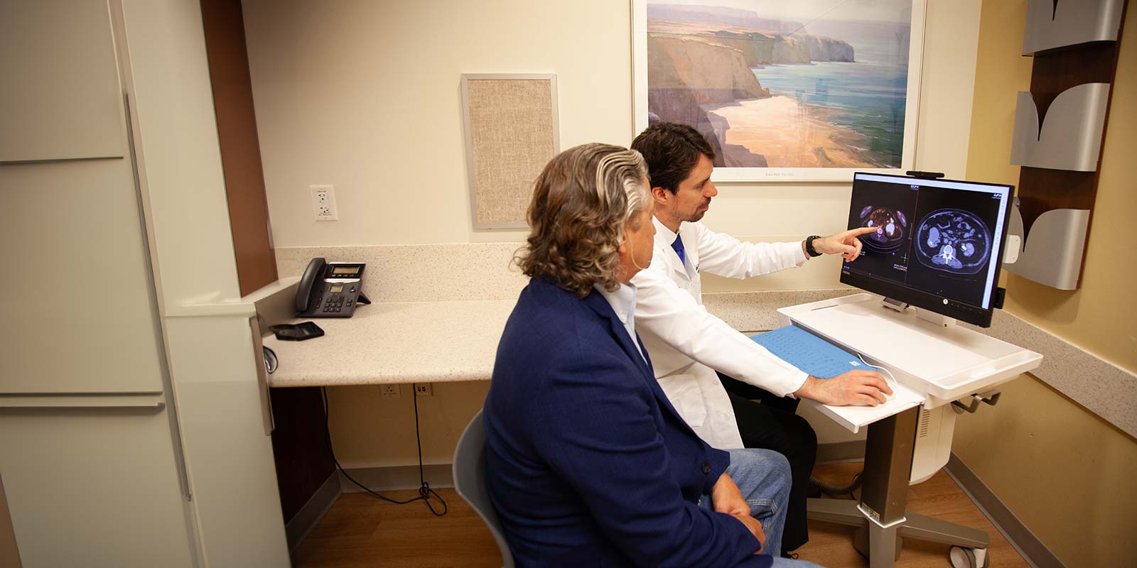Dr. Barata with patient by the computer monitor looking at the PET Scan at Seidman Cancer Center