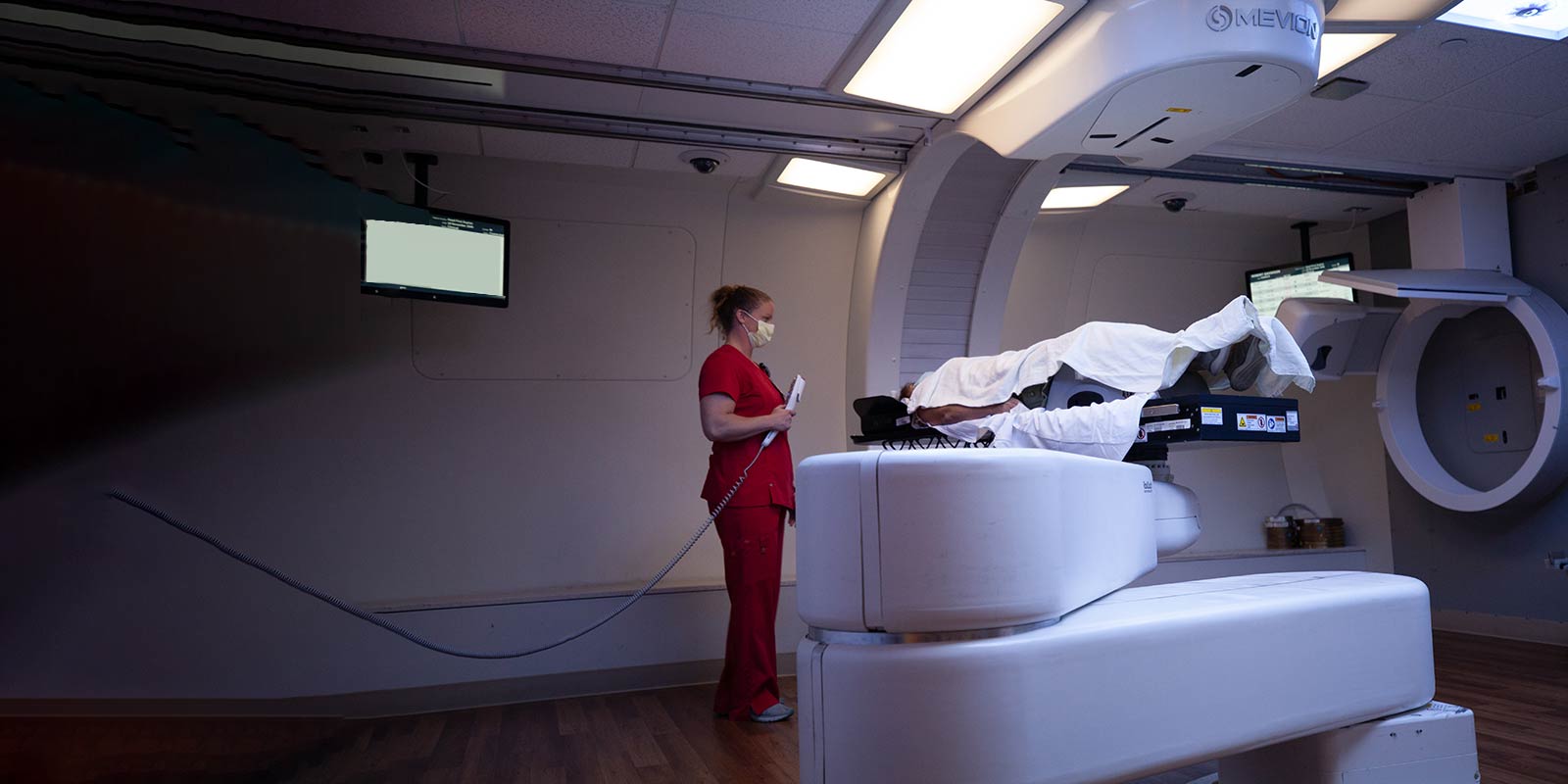 Dr. Choi, Dr. Mansur, therapy personnel performing Proton Therapy on patient