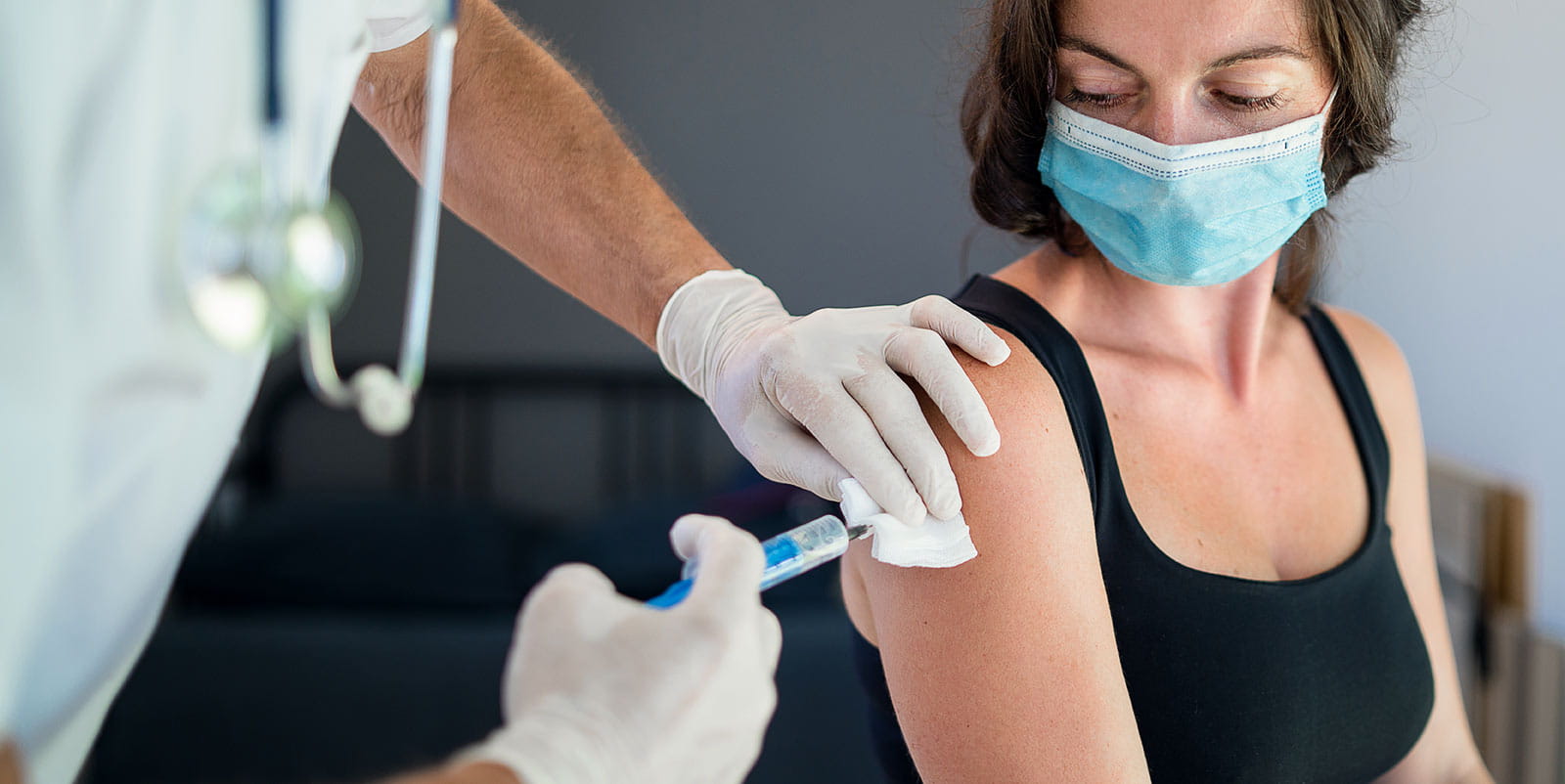 Woman with face mask getting vaccinated
