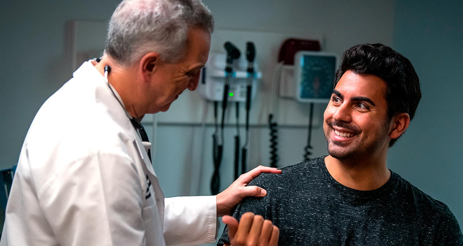 A happy man being examined by an older physician