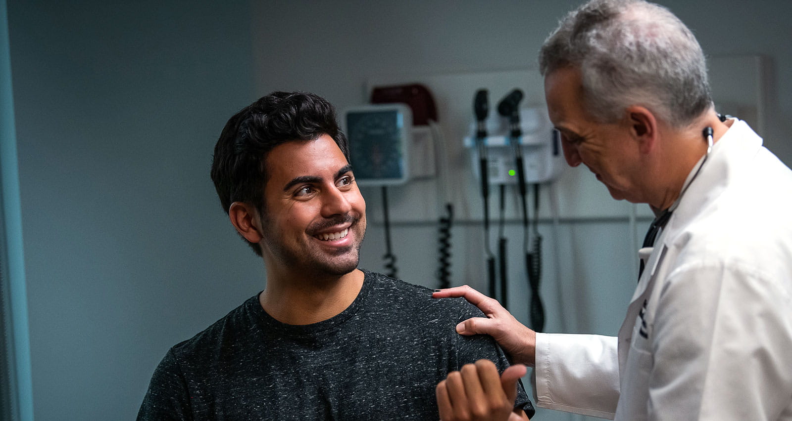 A happy man being examined by an older physician