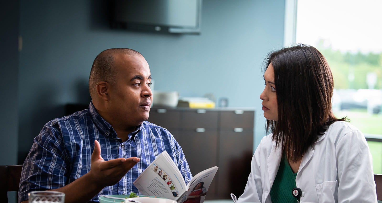 A man discussing treatment issues with his UH provider while sharing a healthy meal