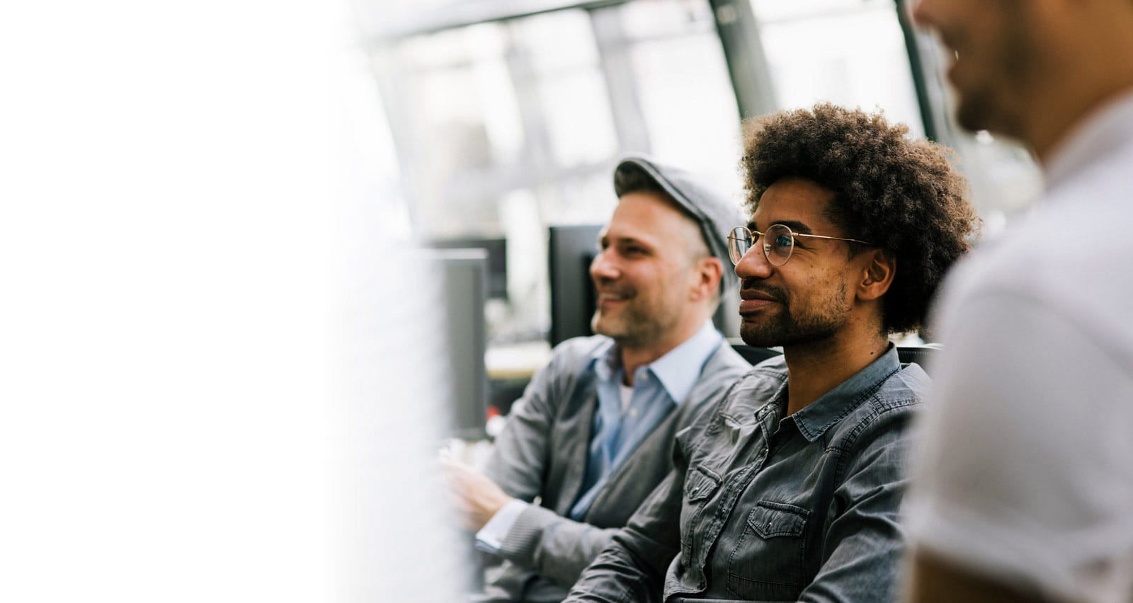 A group of employees listening during a management meeting in a modern office space