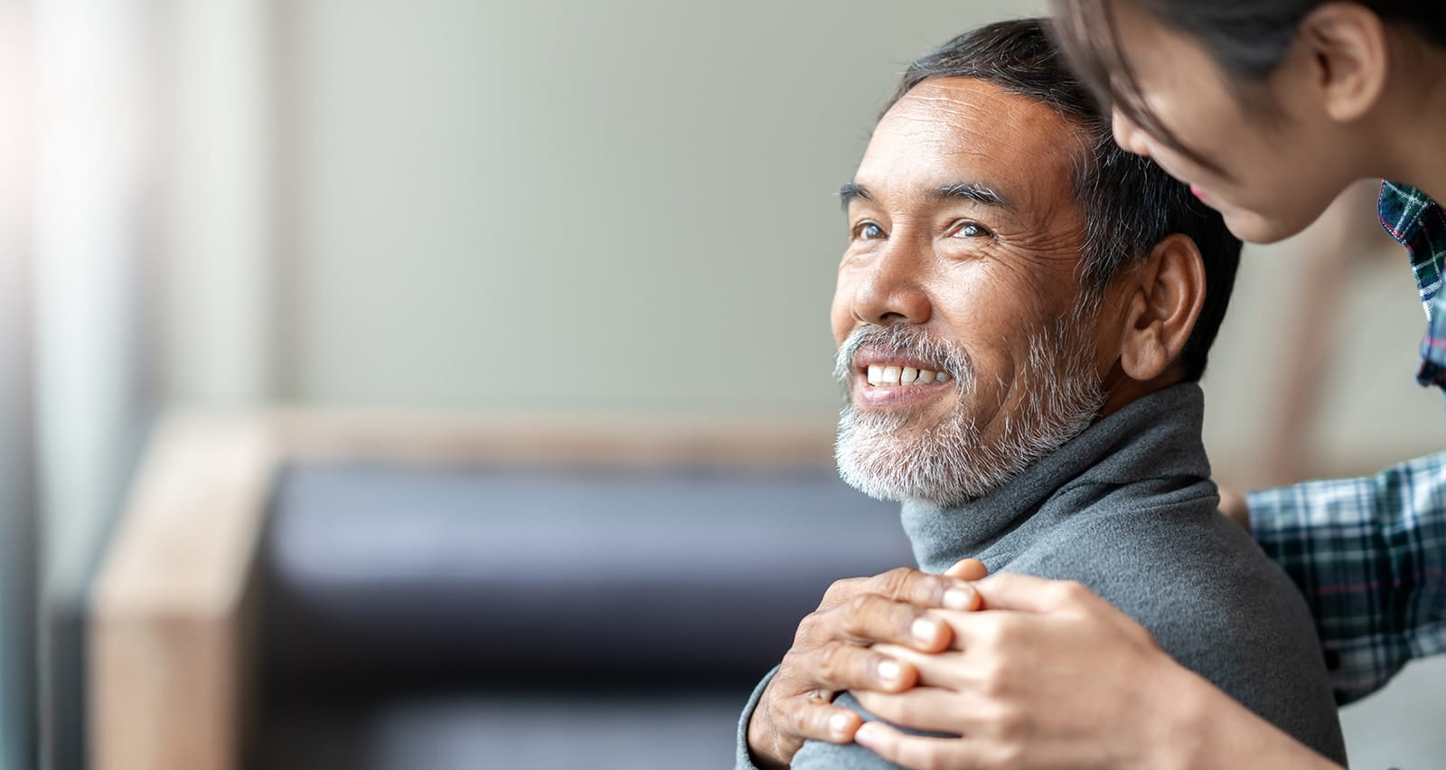 A woman with her hand placed supportively on man’s shoulder