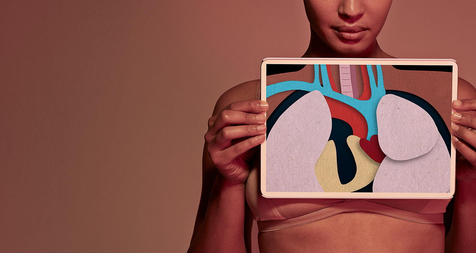 Female holding tablet in front of body to display coloured x-ray illustrations of esophageal area