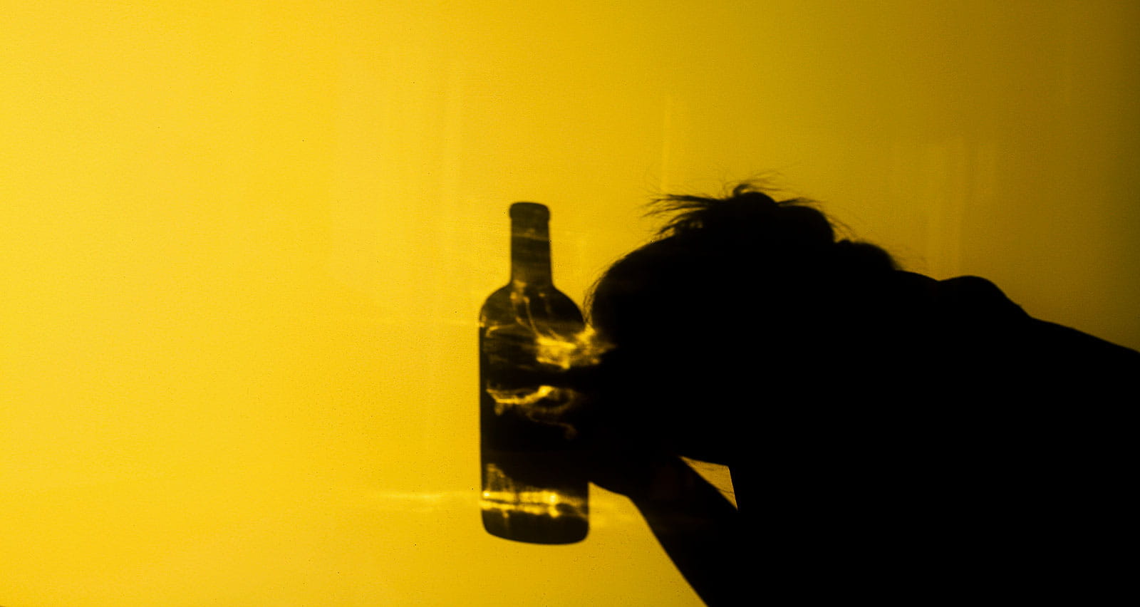Shadow of a woman holding a bottle