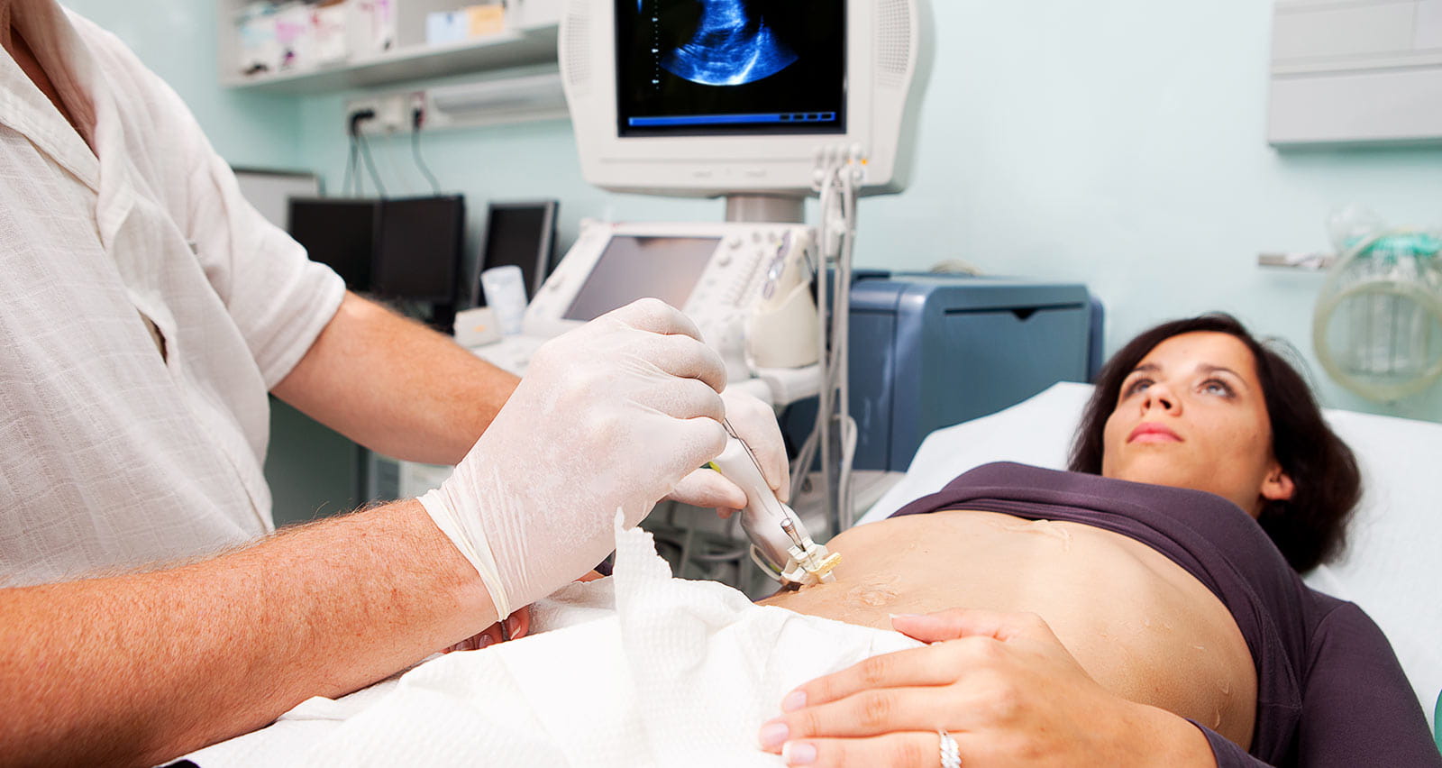Doctor performing liver biopsy on a young woman