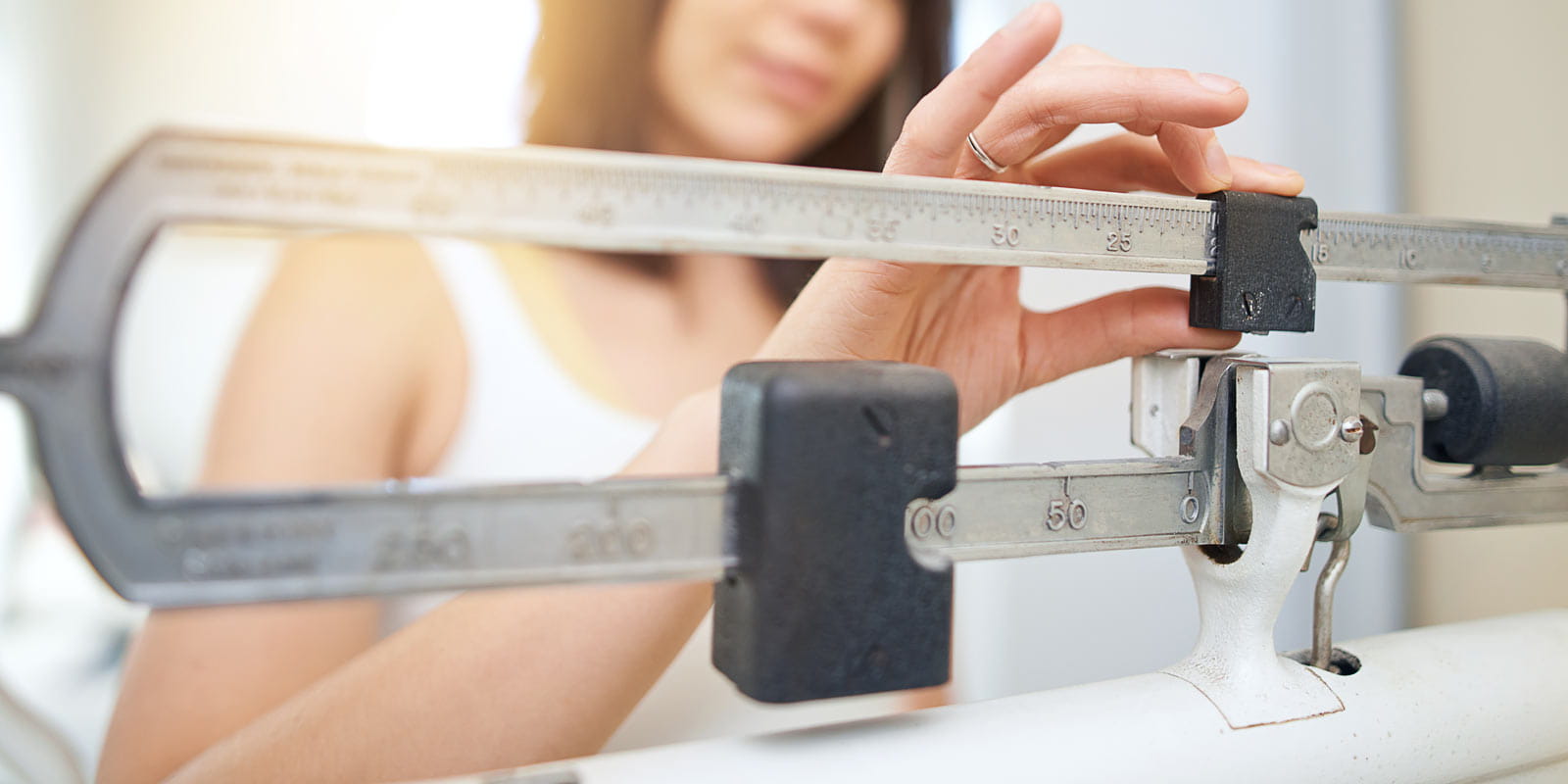 A young woman weighing herself on a scale