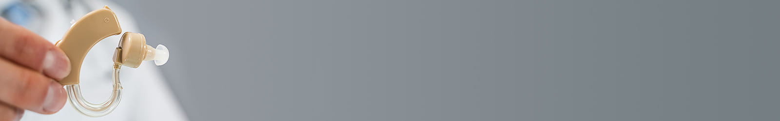 Doctor Holding Hearing Aid Device In Clinic