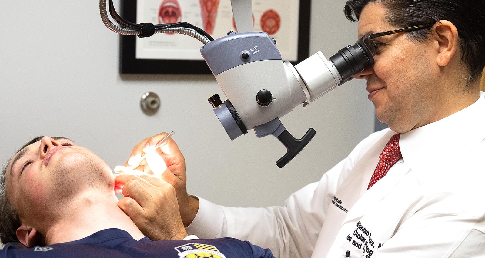 Alejandro Rivas, MD examines a patient's cochlear implant