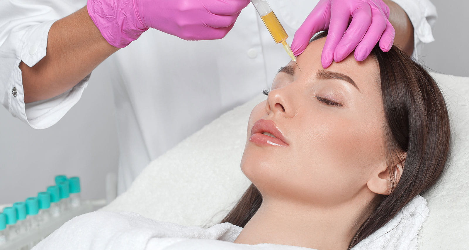 A cosmetologist performs a PRP procedure on a woman
