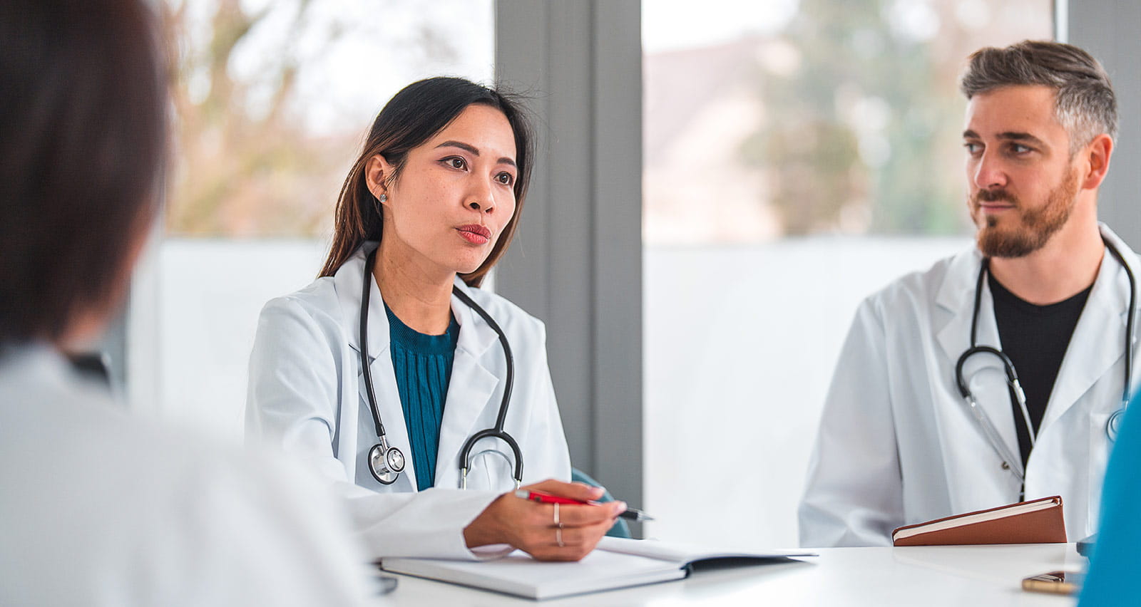 Two providers consult with a patient and his companion