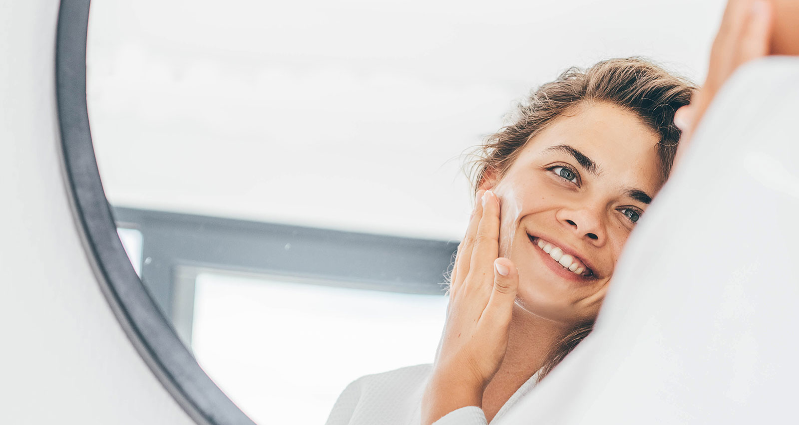 A woman enjoying the routine of applying moisturizing cream on her face