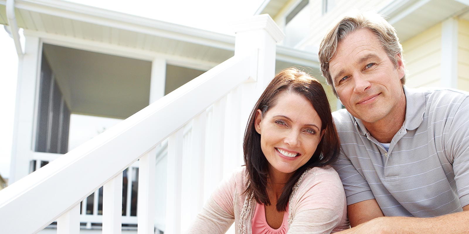 A content couple sitting on a staircase leading to their garden