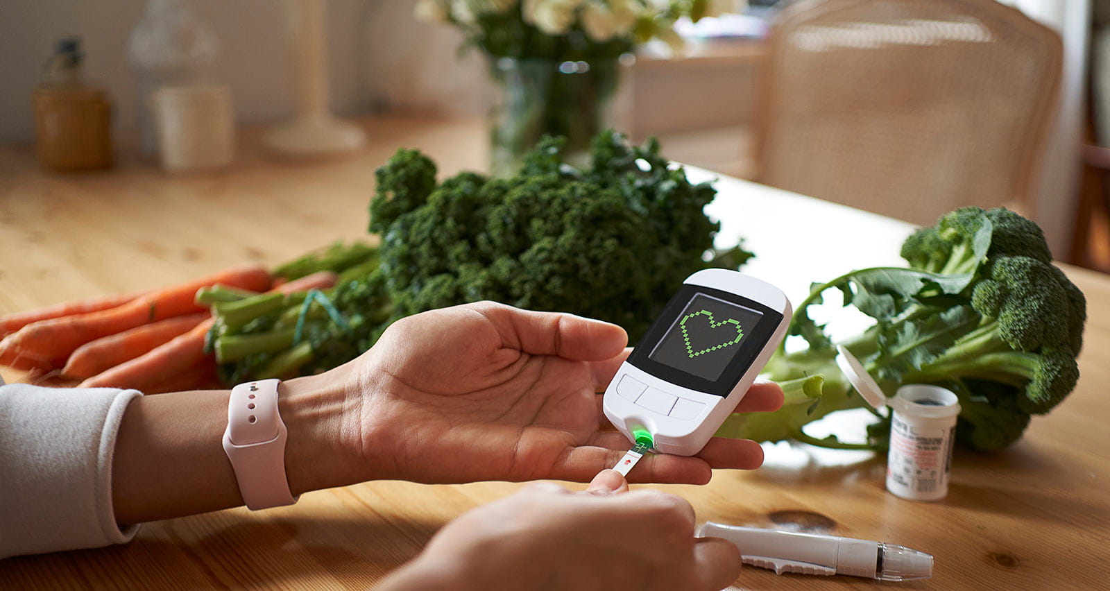 A young woman measuring her blood sugar using glucometer while sitting at the table 