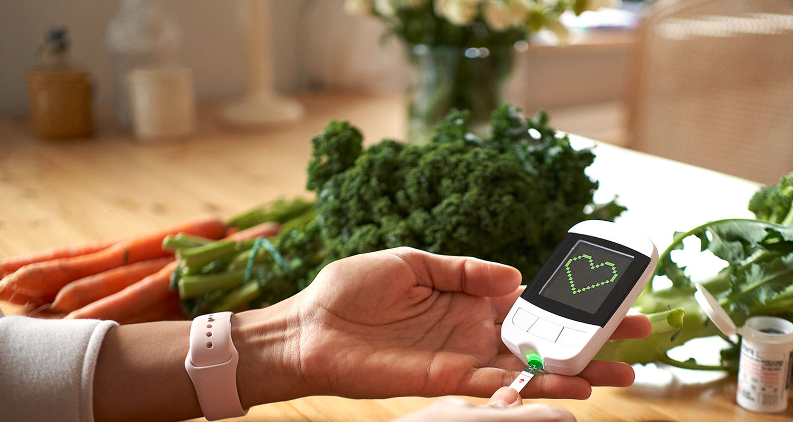 Young woman measuring her blood sugar using glucometer sitting at the table in living room
