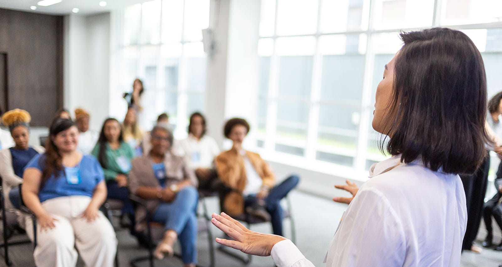 A woman giving a lecture to an audience at a retreat