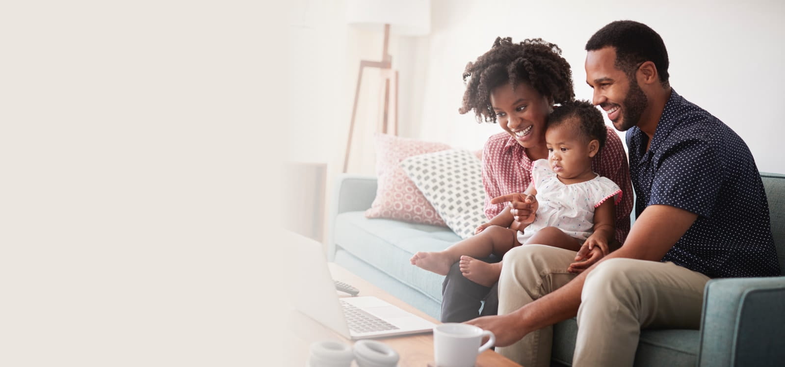Family sitting on couch in front of a computer.