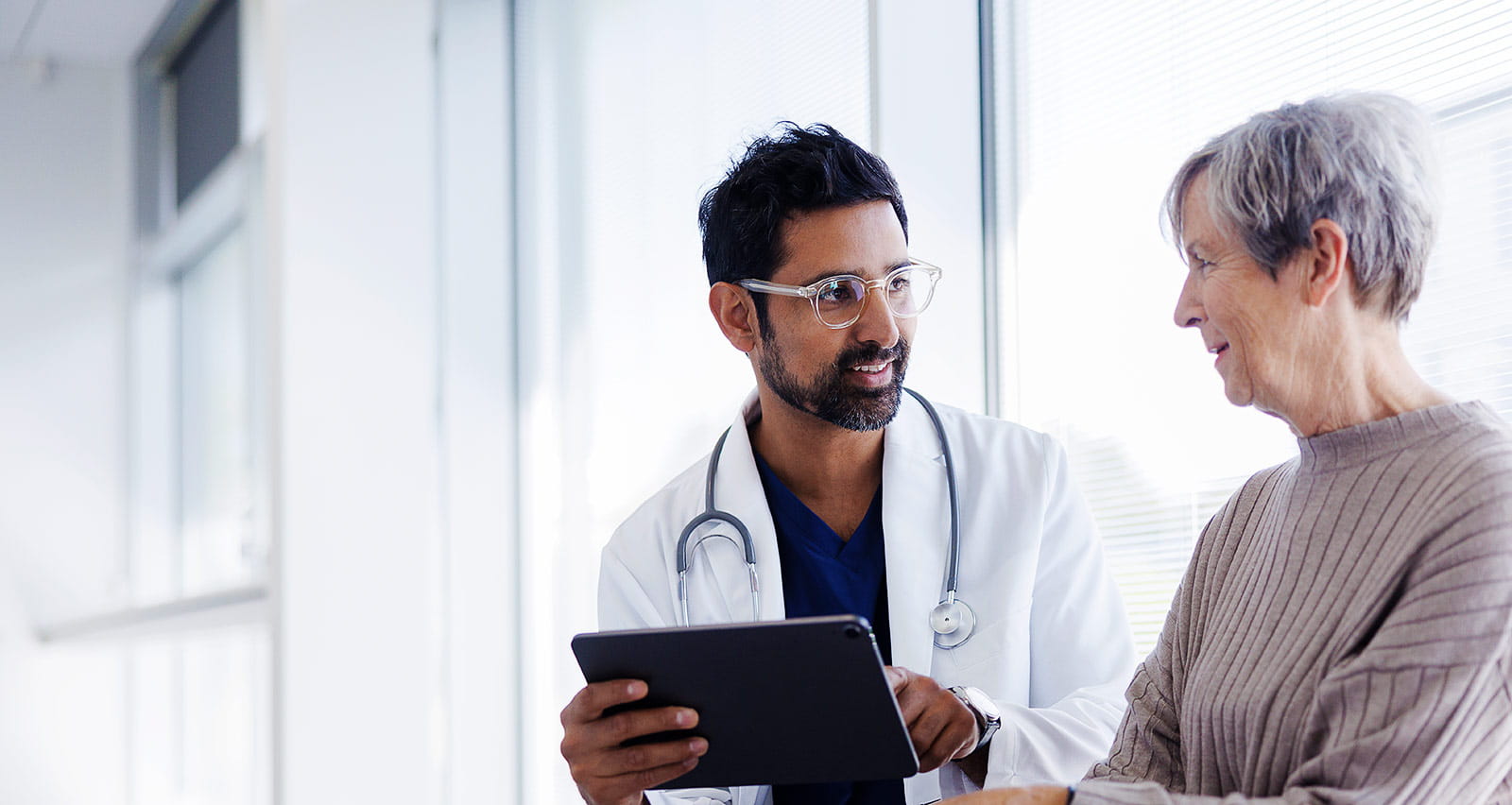 Doctor and patient in conversation, looking at digital tablet