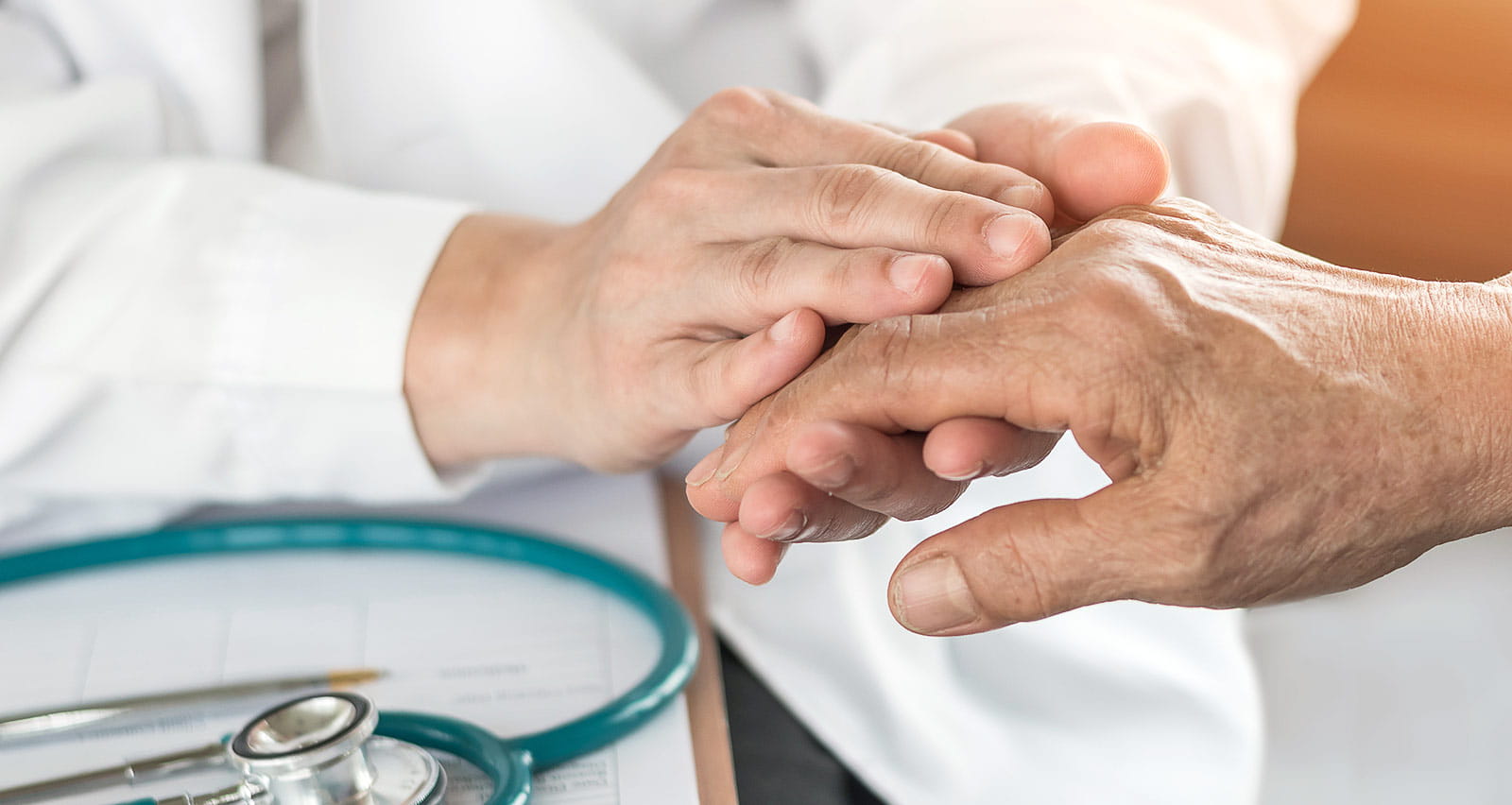 A senior patient being comforted by a geriatric health provider