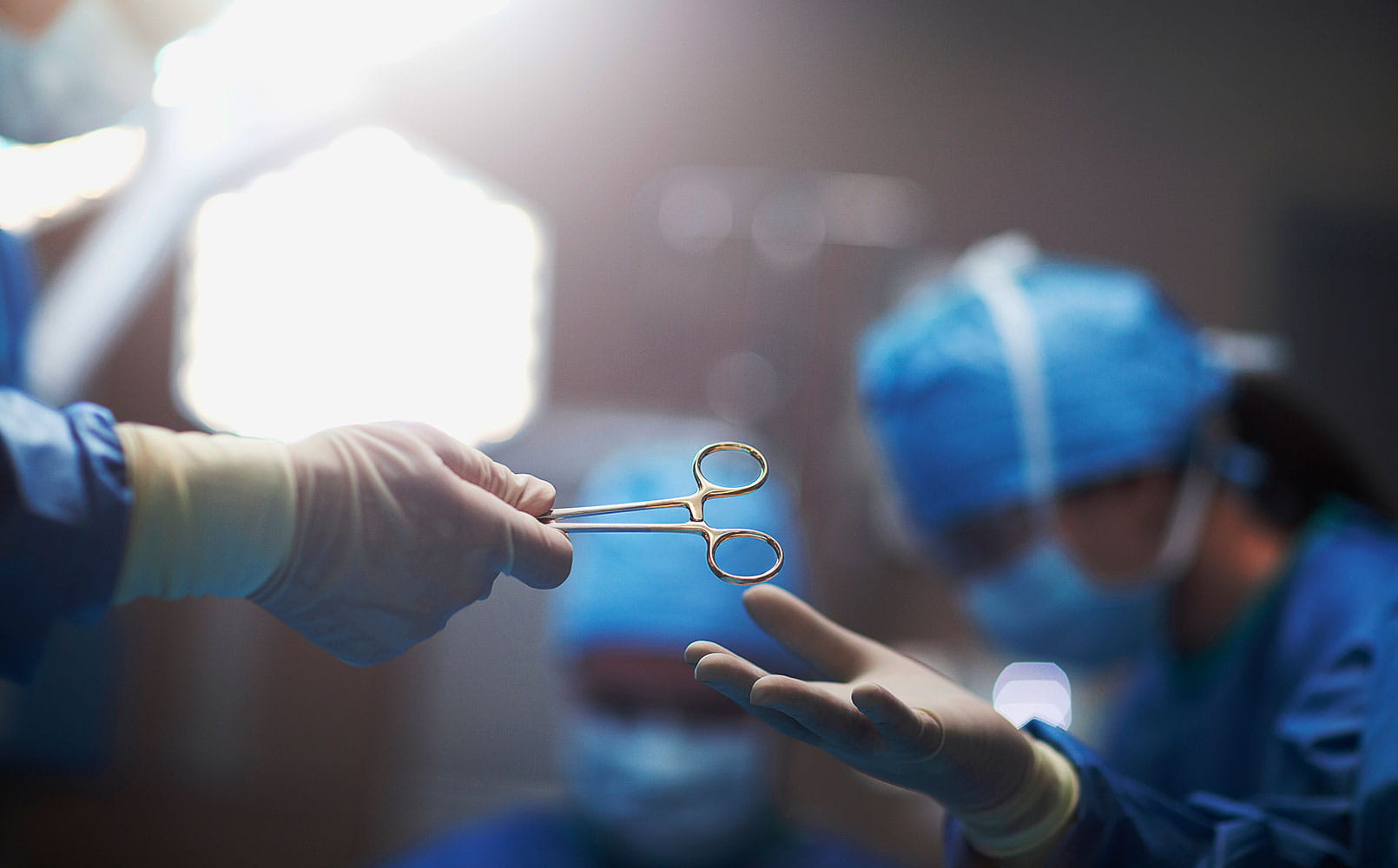 The hands of surgeon or nurse passing a medical tool in surgery operating room