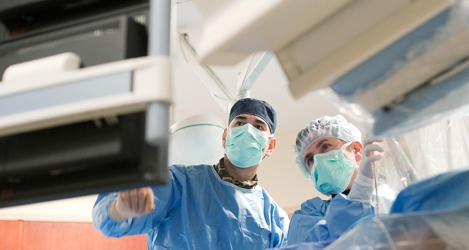 Two heart surgeons checking information on a monitor