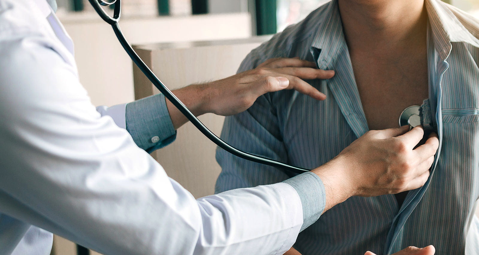 A doctor uses a stethoscope to listen to the heartbeat of a patient