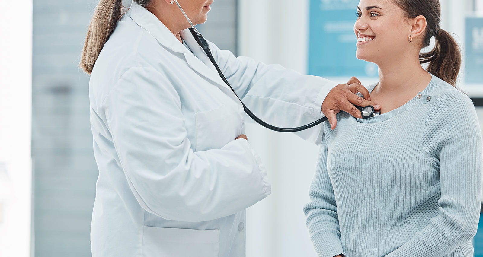 A doctor examining a patient with a stethoscope during a consultation