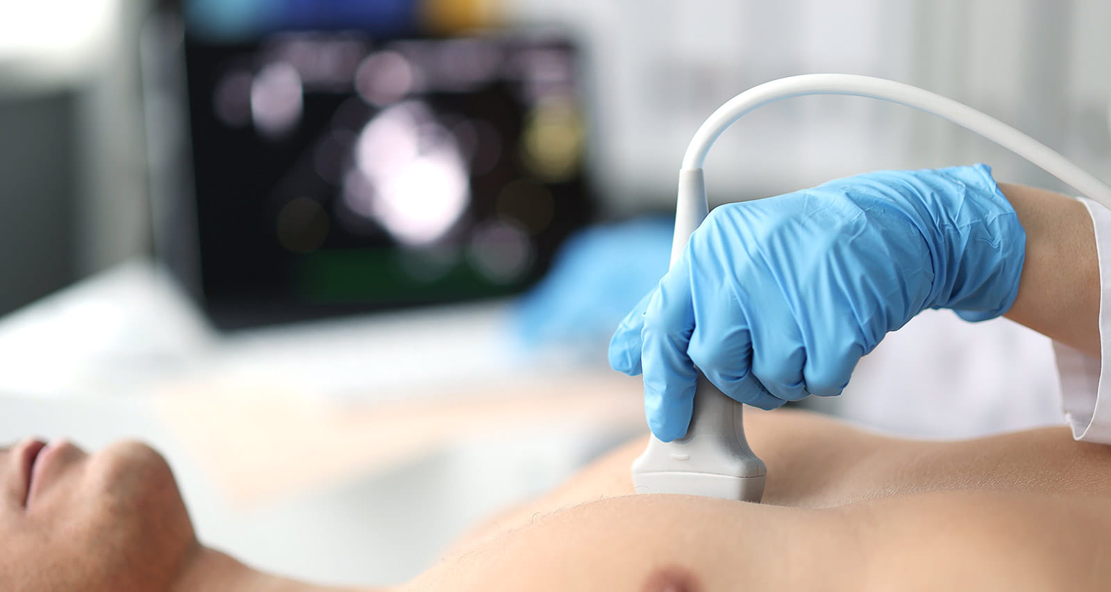 Doctor performs chest ultrasound on man in hospital room