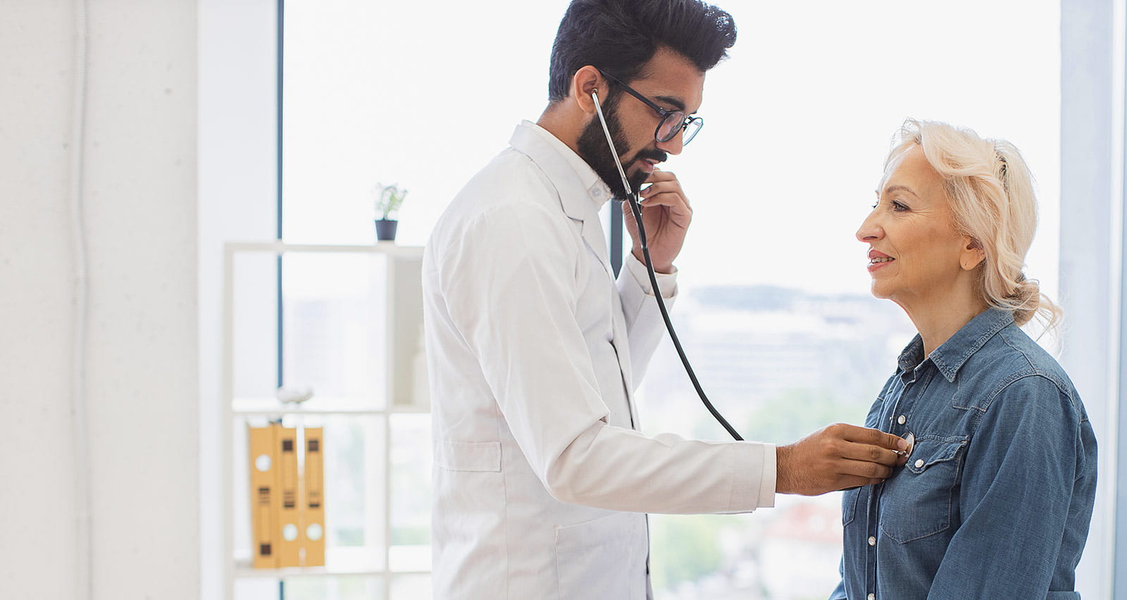 A general practitioner examining his patient's heartbeat while providing a regular checkup in a clinic