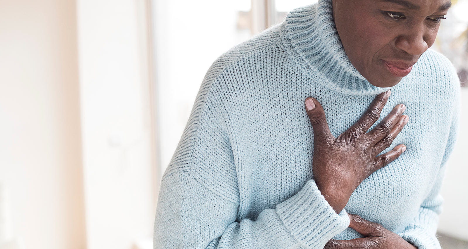 Mature woman holding chest in pain