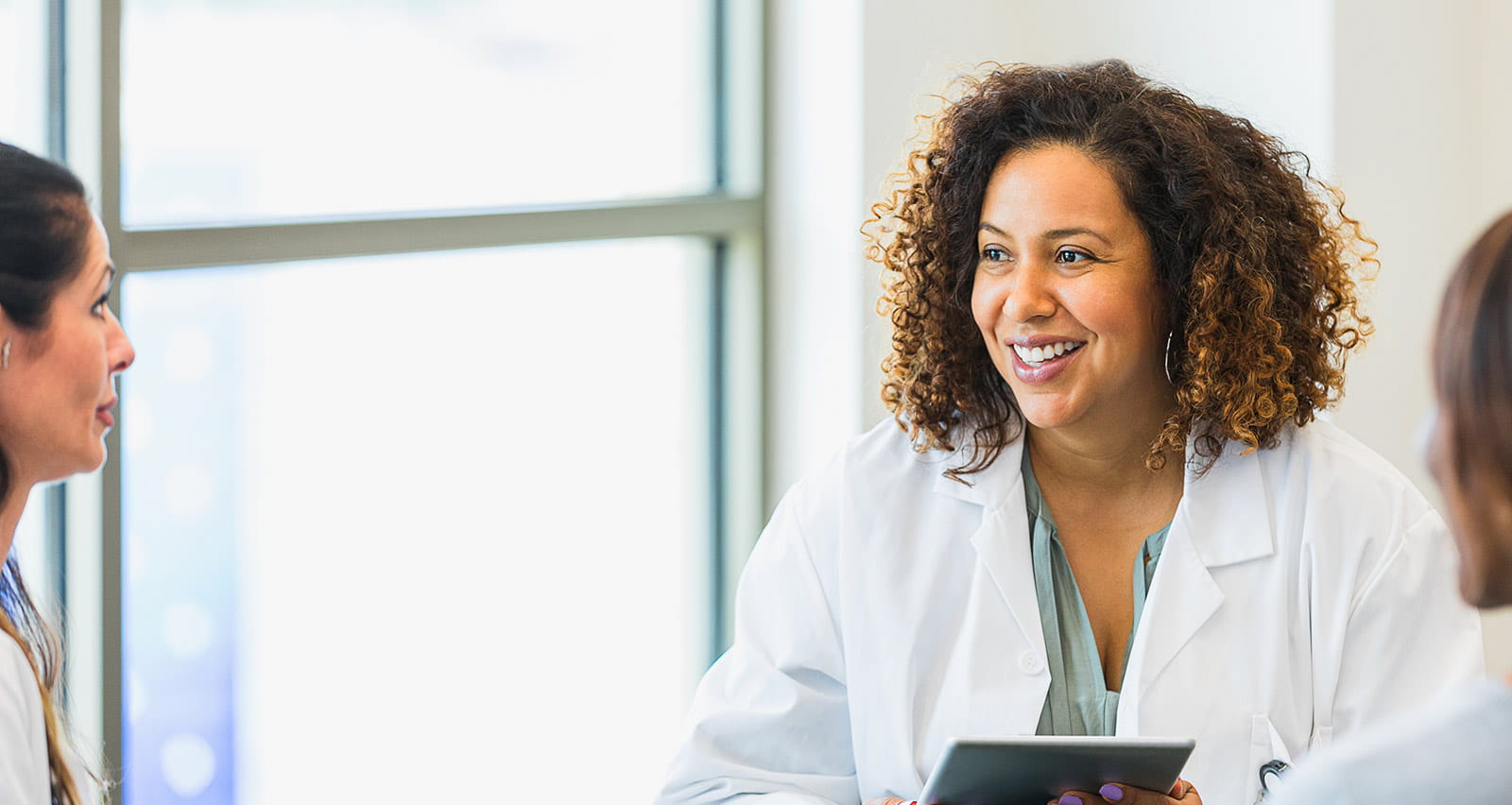 A diverse group of female medical specialists meet together