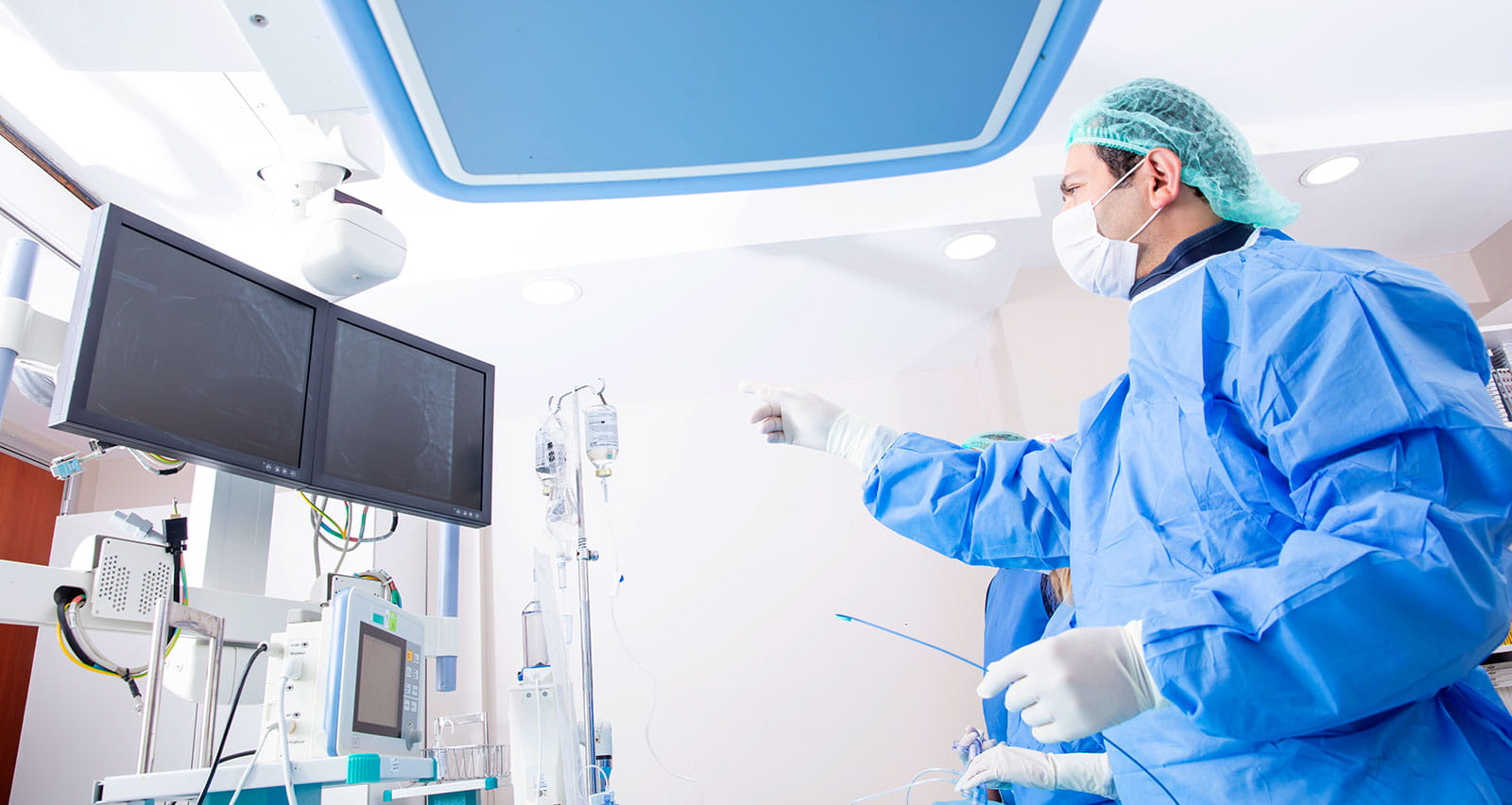 Cardiac surgeon viewing video monitors in surgery