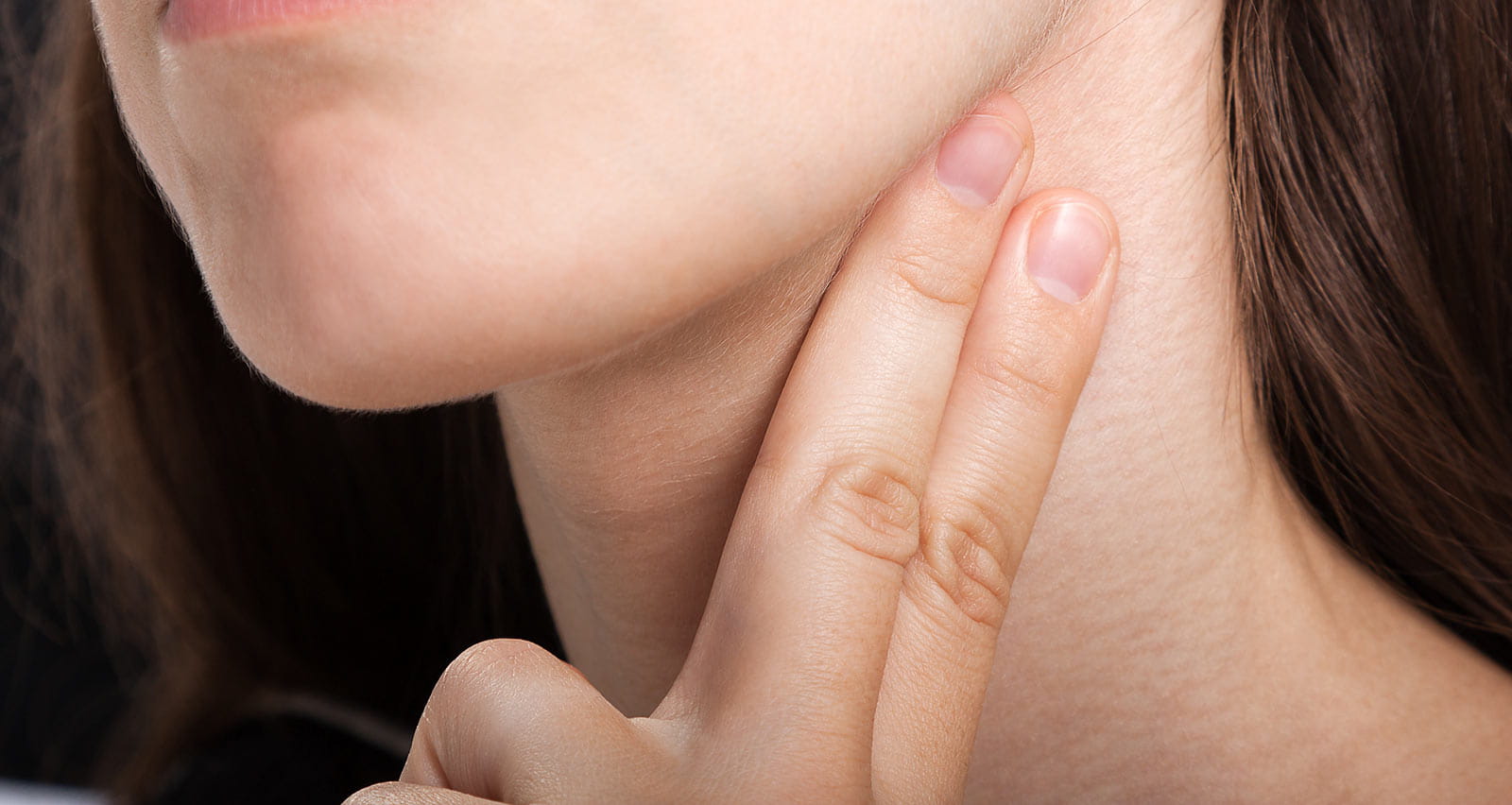 A woman measuring her neck pulse