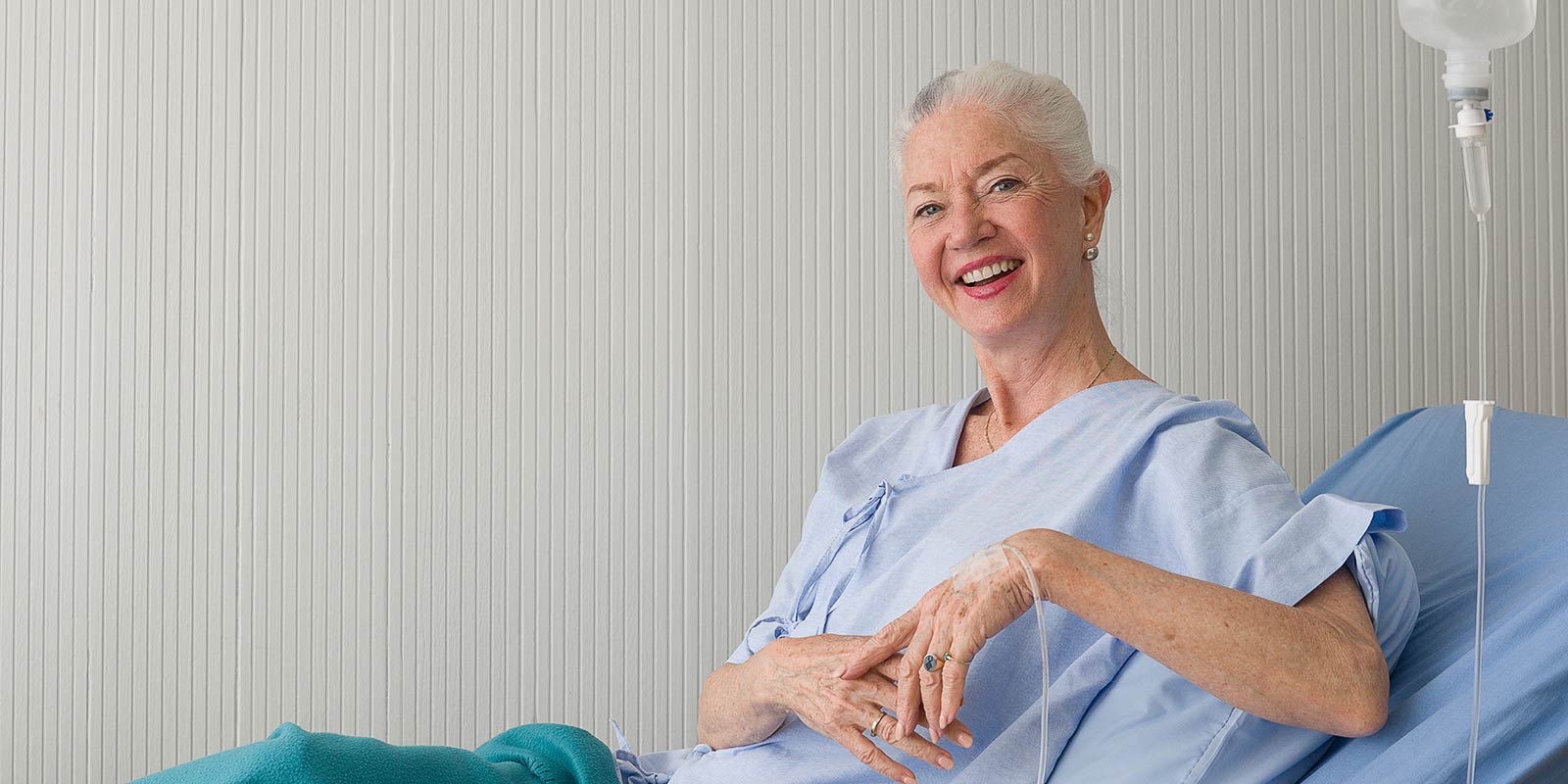 Elderly female patient lying on the bed receiving infusion