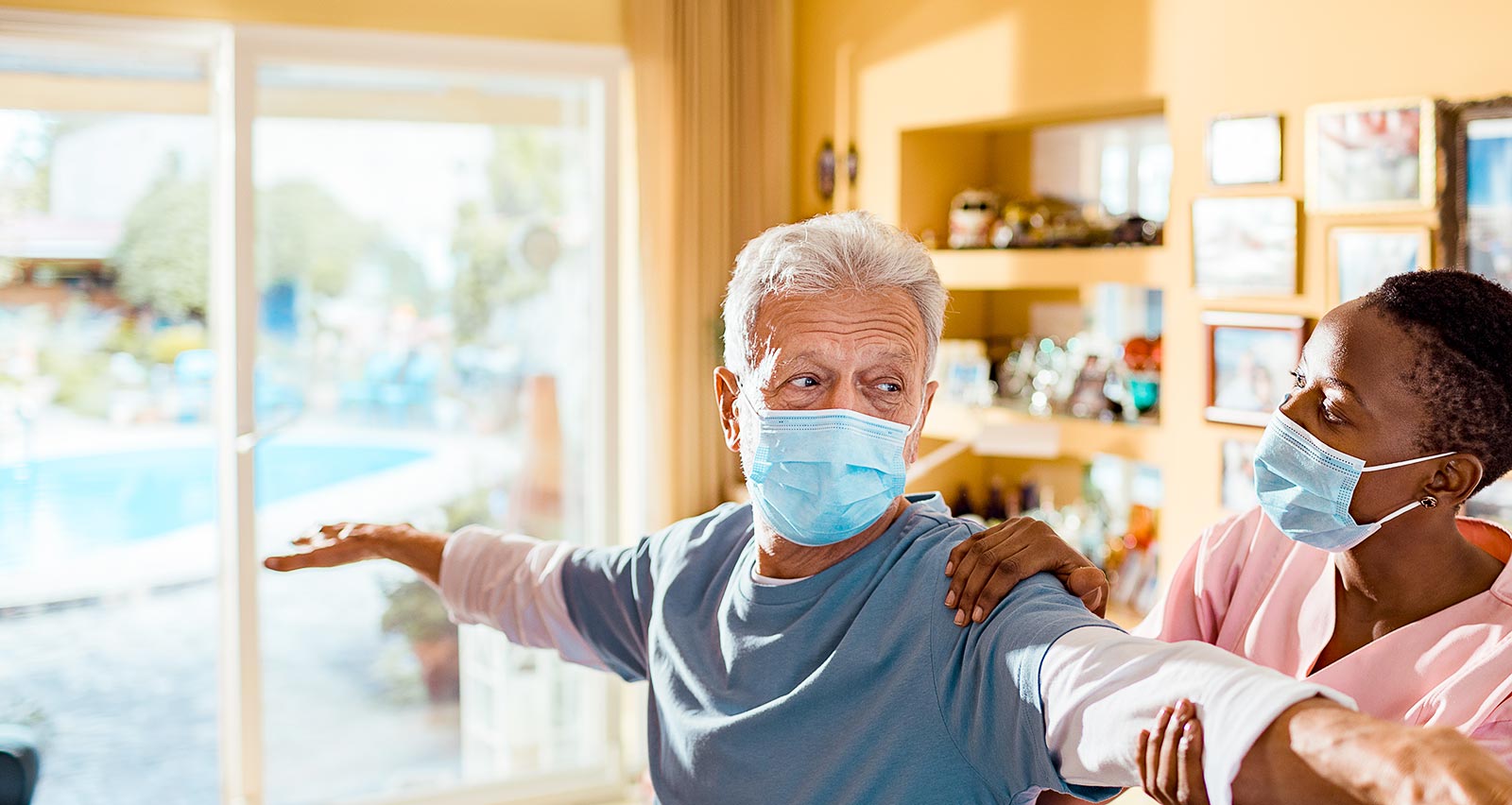 A young female caregiver gives physical therapy to her patient