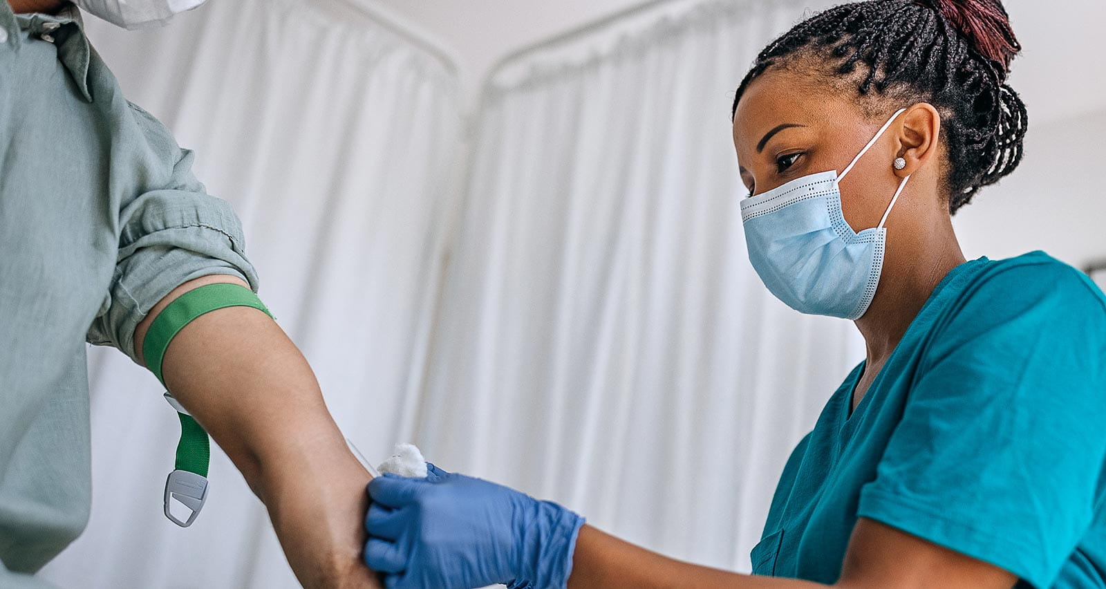 A nurse taking blood sample from patient
