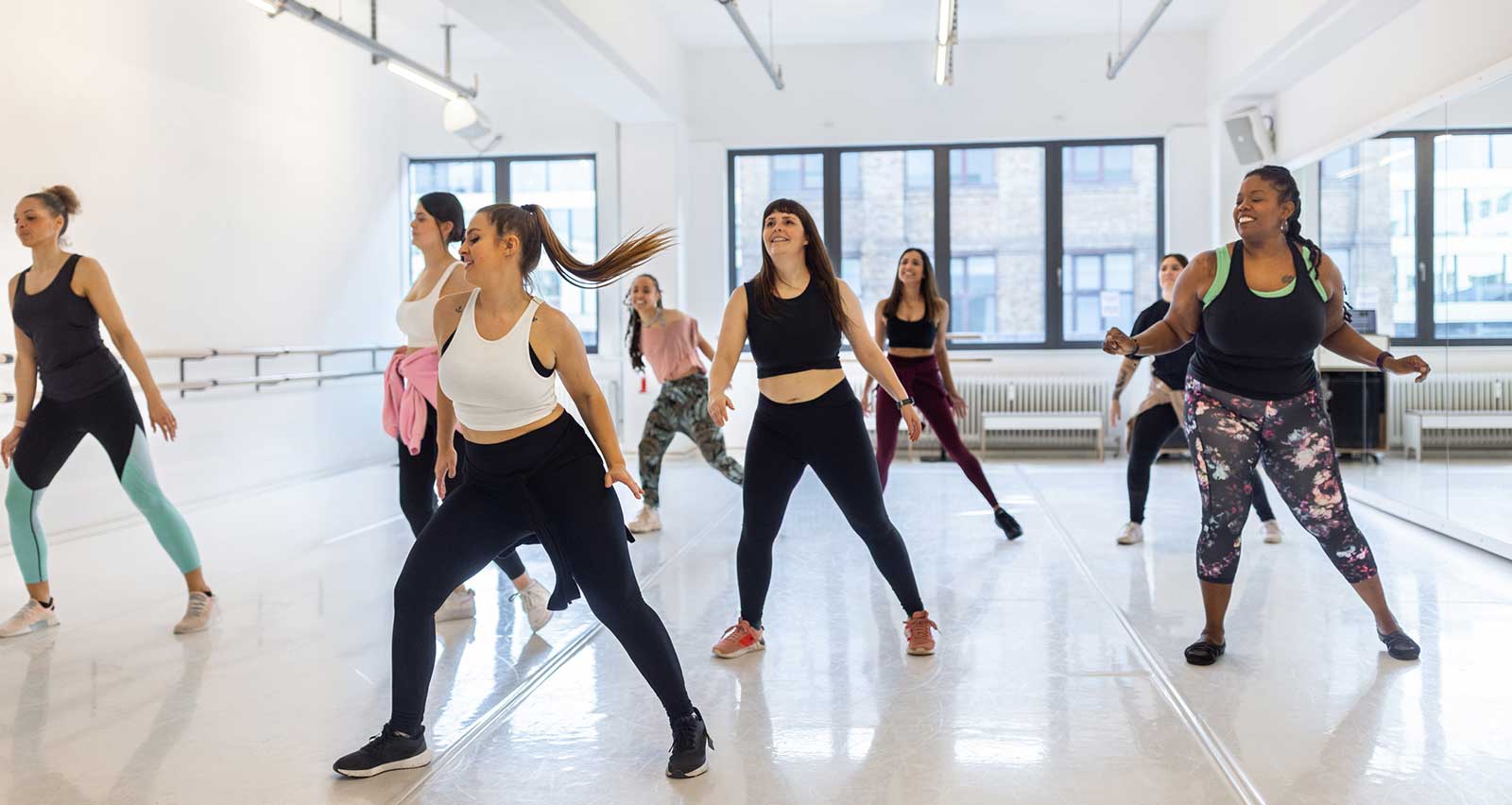 Multiracial women enjoy a dance routine at an exercise class