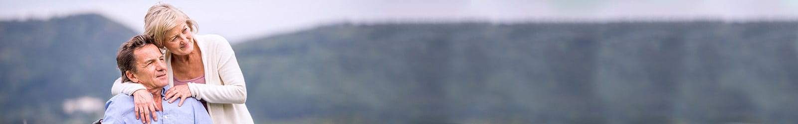 Man using wheelchair enjoying the scenery outdoors with his wife.
