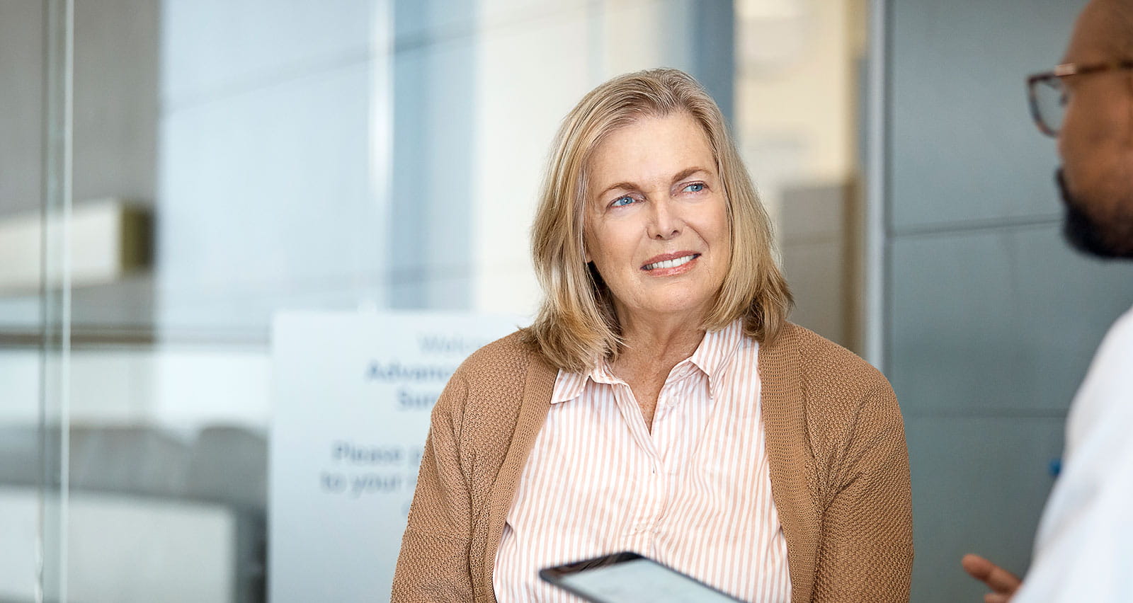A senior woman listening to a medical professional in hospital
