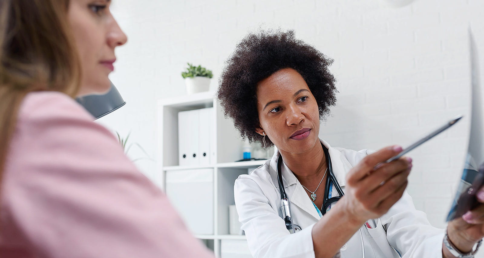 A female doctor shows mammogram test results to her patient