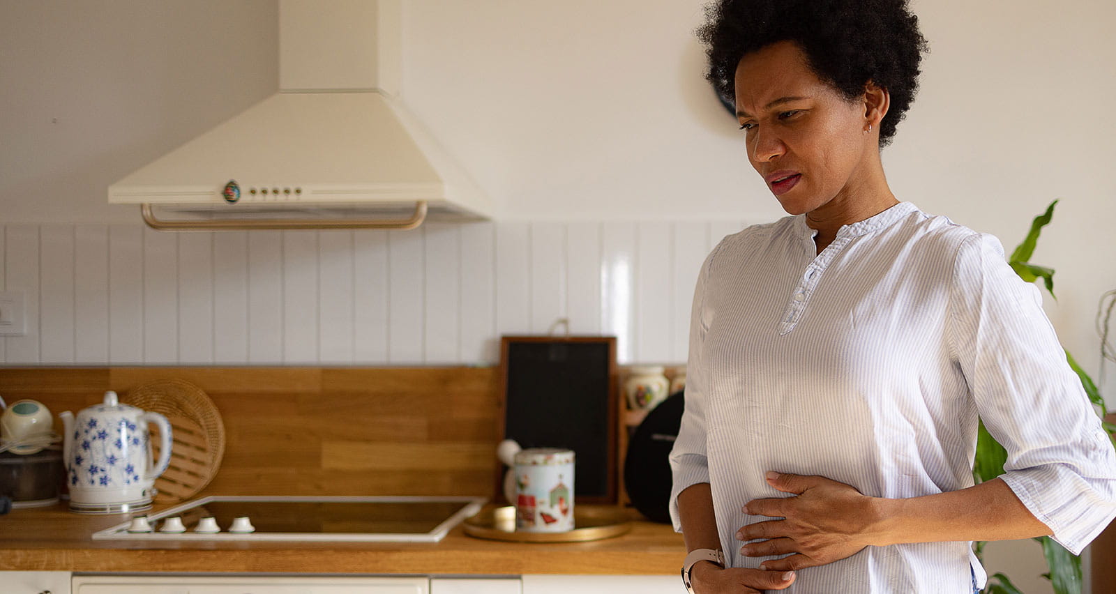 A woman holding her midsection in pain