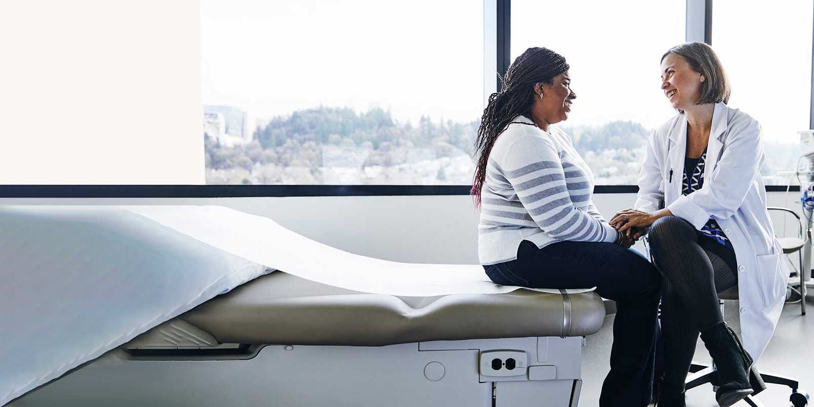 Smiling female doctor talking to woman in hospital
