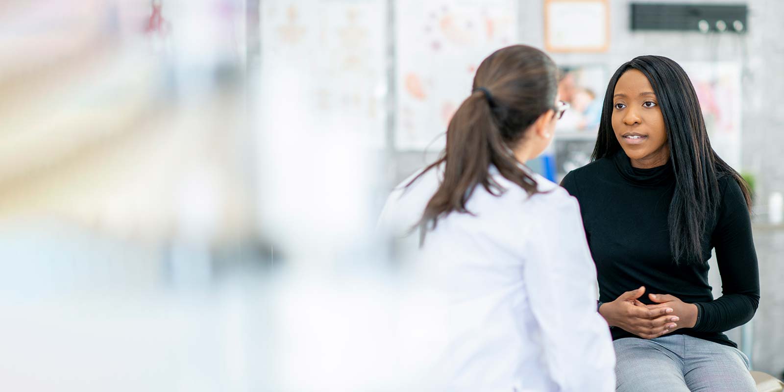 Young woman talking to a female doctor in an office