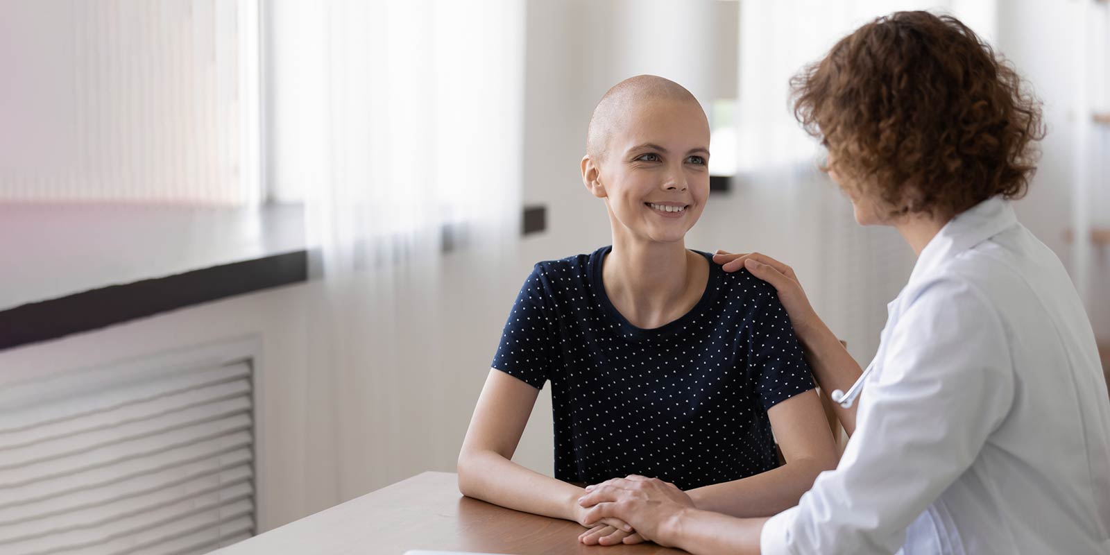 Young woman with cancer consulting with doctor