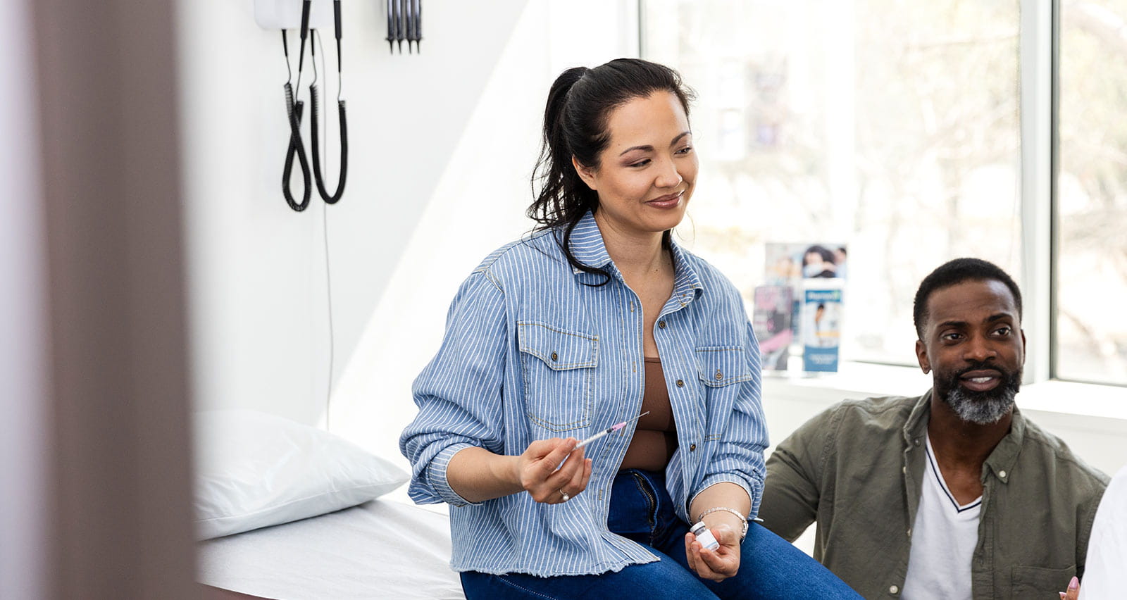 A couple is discussing IVF with their female doctor in a treatment room